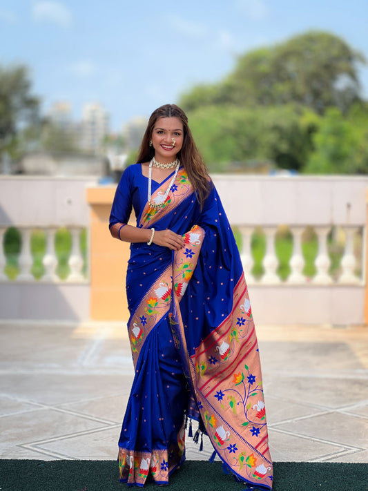 Woman wearing a blue saree with floral patterns outdoors