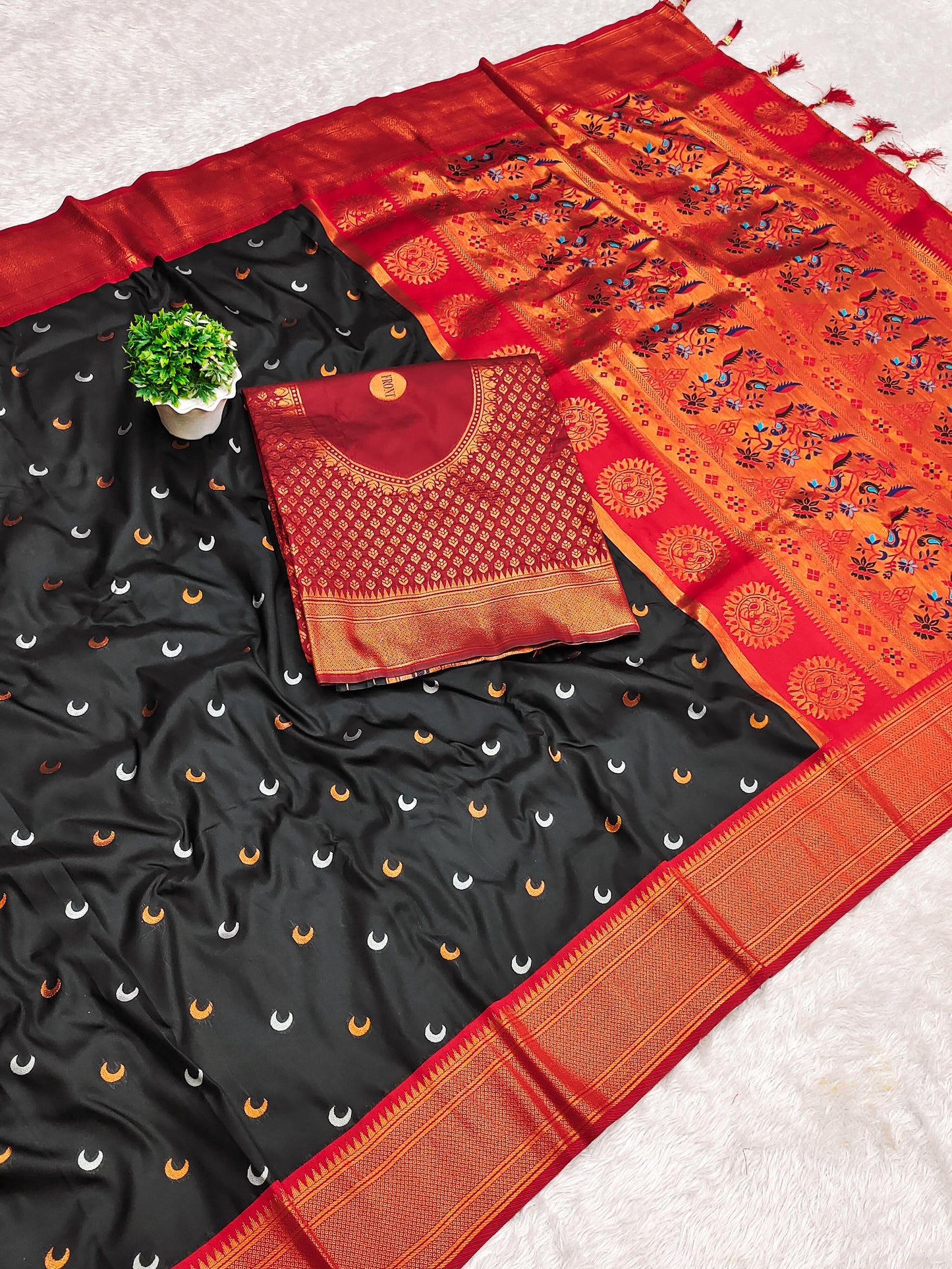 Black and orange saree with a blouse piece on a light gray background